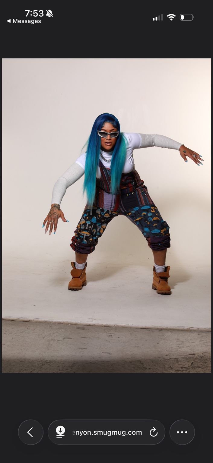 Karson Blu in a studio portrait, wearing sunglasses and patterned pants