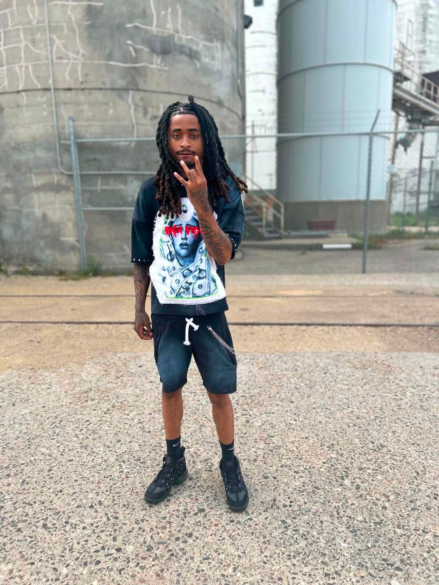 KT Mello outdoors in front of industrial tanks